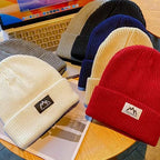 Set of ribbed knit beanies with folded cuffs and woven brand patches.