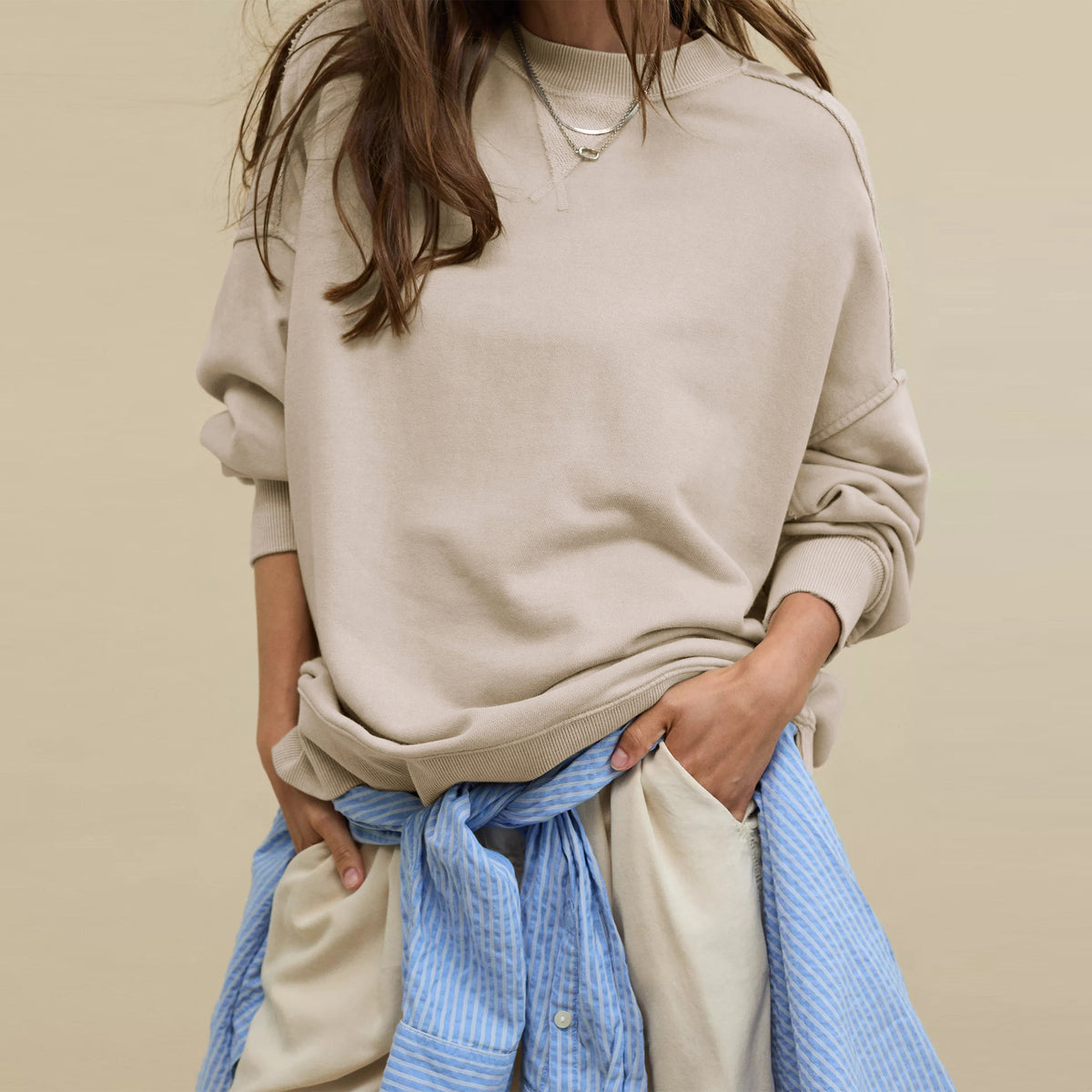 Oversized crewneck sweatshirt in light beige with exposed seams and slouchy fit