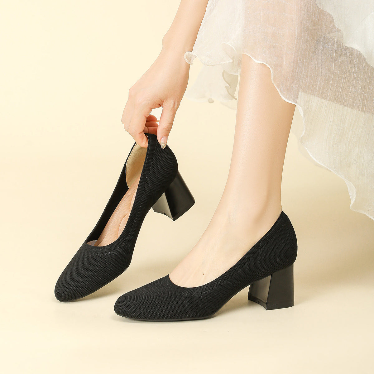 Black knit block heel slip-on pumps with rounded toe and textured fabric