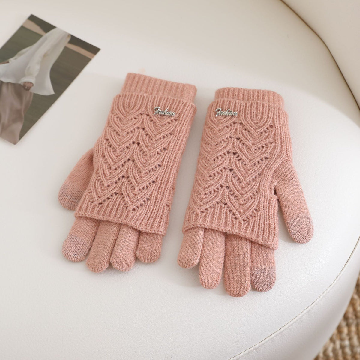 Women’s pink fingerless knit gloves with ribbed cuffs and textured wave pattern