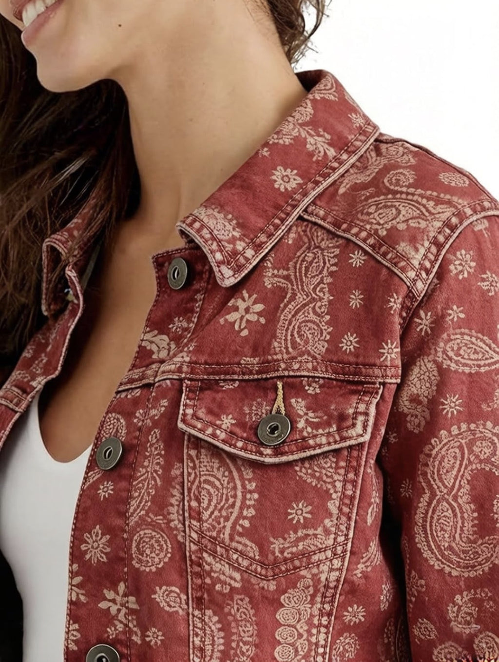 Close-up of women’s paisley print denim trucker jacket collar and front buttons, red-brown