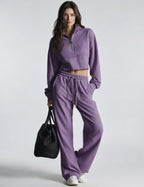 Purple women's sweatsuit with cropped half-zip sweatshirt and wide-leg drawstring pants
