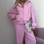 Women’s pink zip-up hoodie and matching drawstring sweatpants set in soft fleece.