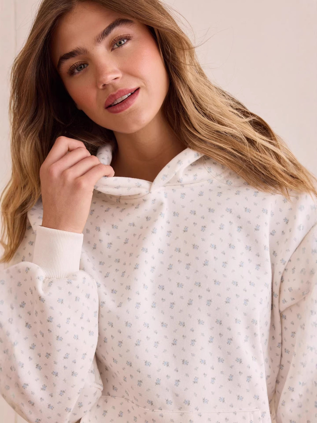 Close-up of white ditsy floral hoodie neckline and kangaroo pocket pouch