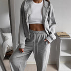 Women’s heather gray zip-up hoodie and drawstring sweatpants set, soft fleece.
