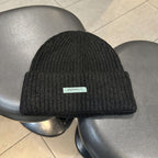 Black ribbed knit beanie with wide cuff and woven "pipiswoot" label