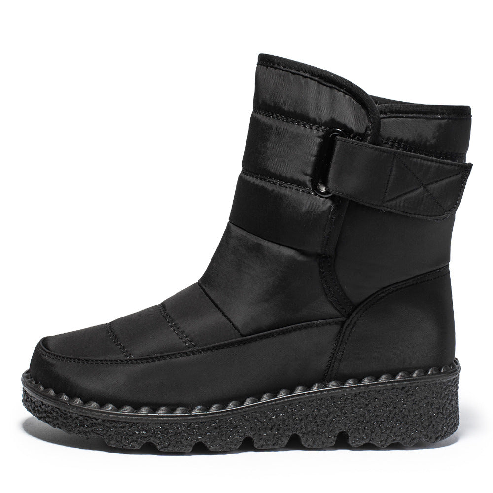 Black quilted platform snow boot with padded ankle collar, side strap, and textured outsole.