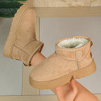 Women’s tan short snow boots with zipper seam, thick sole, and fleece-lined cuff