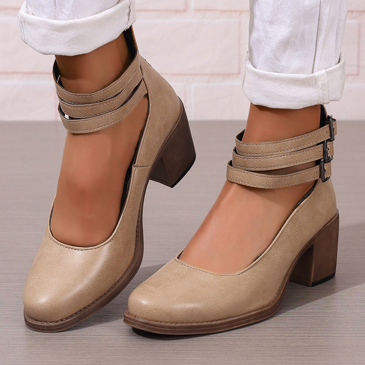 Beige closed-toe block heel pumps with ankle strap and buckle closure