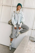 Women’s sherpa jacket in light blue with snap front and stand collar; zip pockets