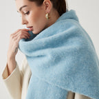 Oversized fuzzy mohair-blend scarf with fringe ends, light blue, worn draped over shoulders