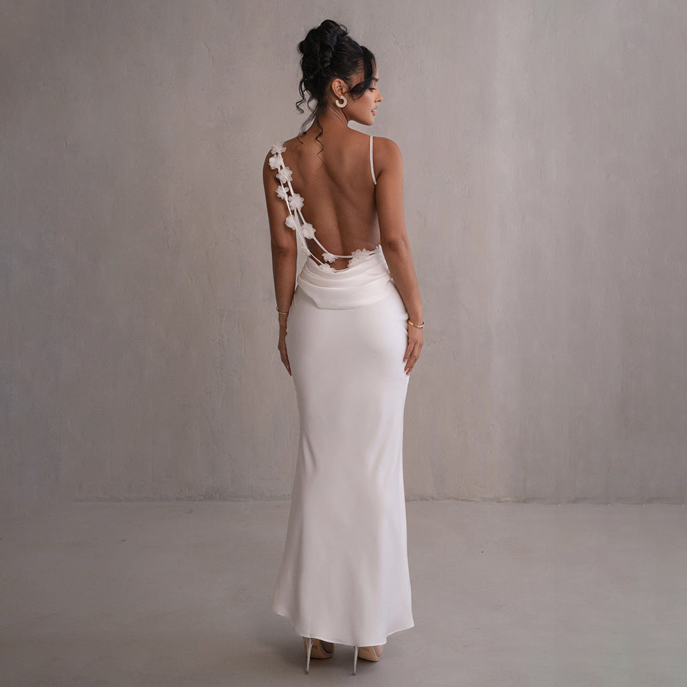 White satin maxi dress with backless design and lace-trim rosette straps.