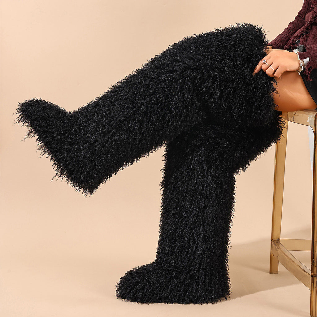 Black shaggy faux fur thigh-high boots, one leg extended to show the boot shape.
