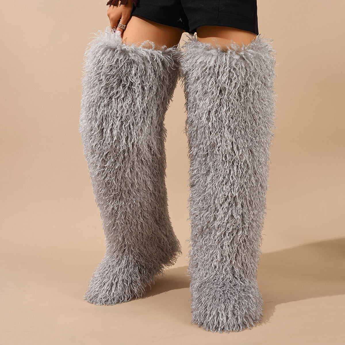 Light gray shaggy faux fur boots shown worn to the thigh.
