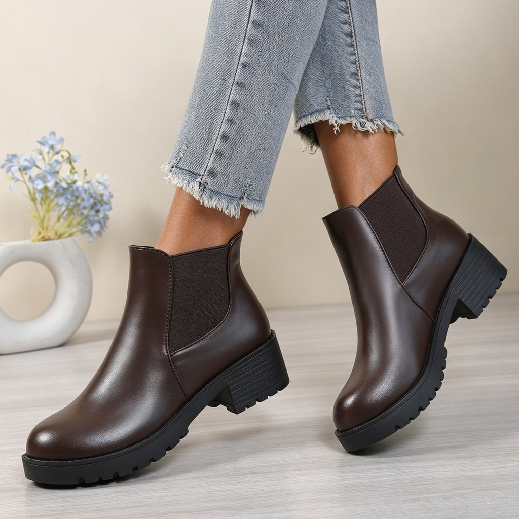 Women’s chunky Chelsea boots in dark brown, side view with elastic panels and lug sole.