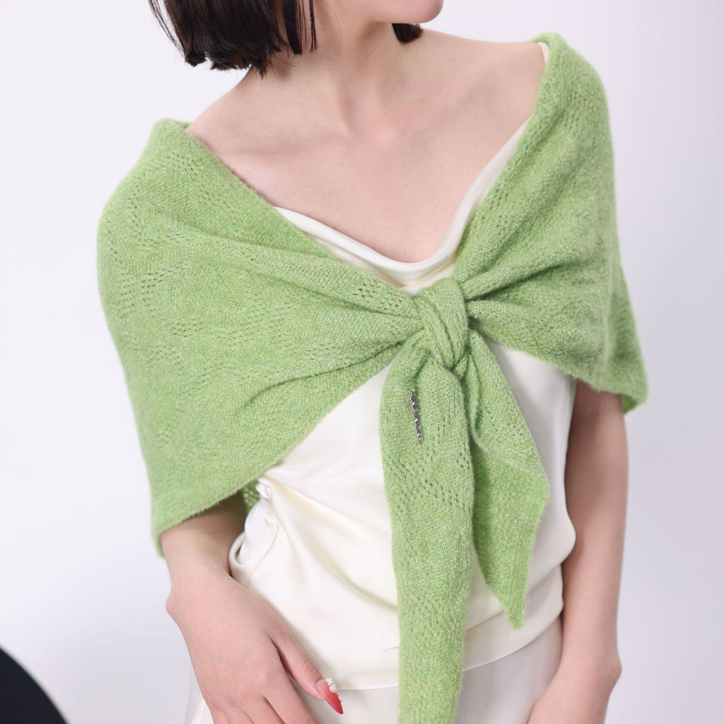 Light green knit triangle scarf worn as a shoulder wrap and tied at the front.
