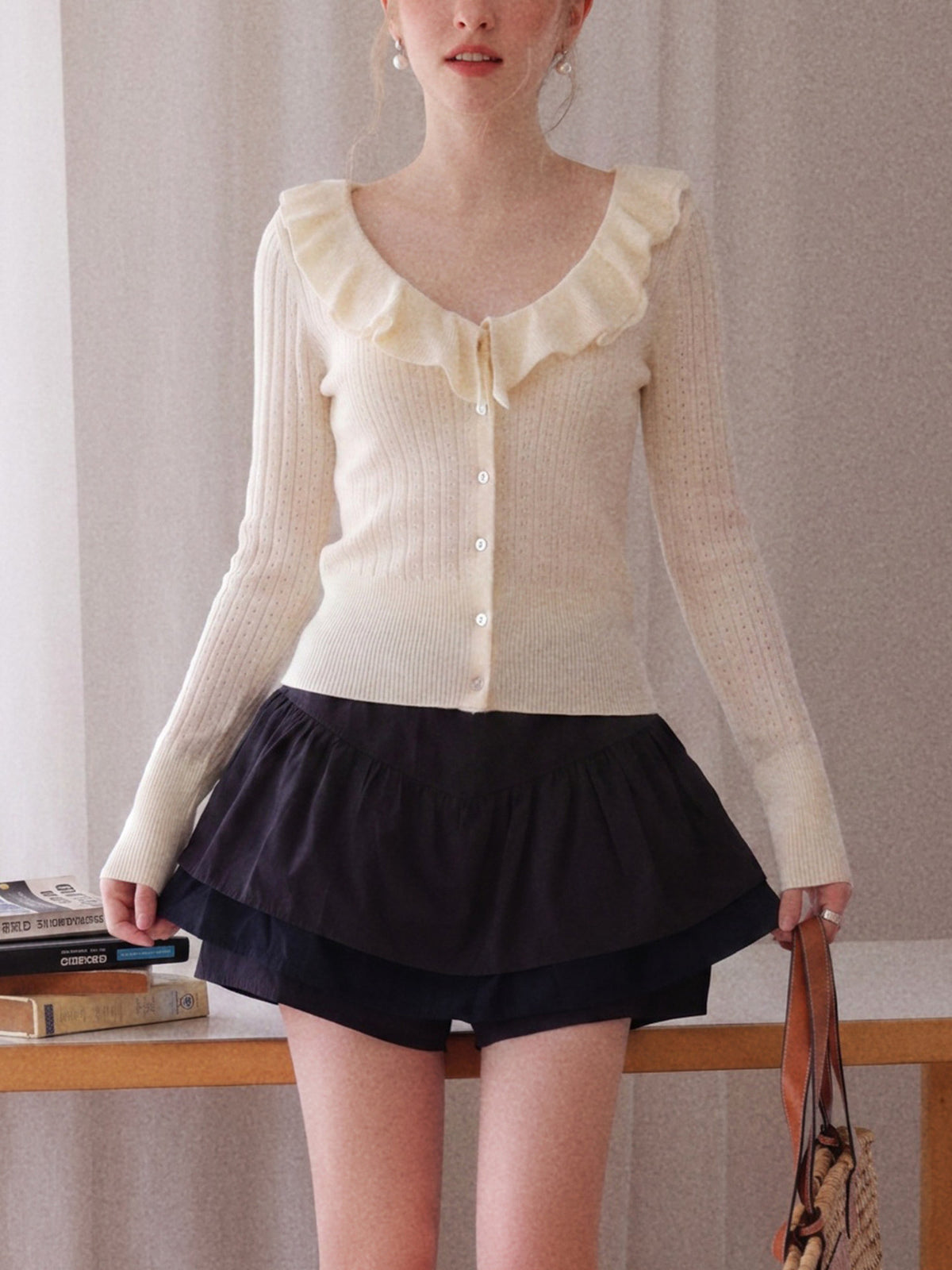 Off-white knit cardigan with ruffle V-neck collar, button front, fitted long sleeves