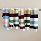 Women’s striped wool scarves, wide knit stripes in assorted blue, cream, pink, and maroon.