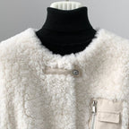 Detail of the jacket's collarless neckline, snap tab, and zip chest pocket.