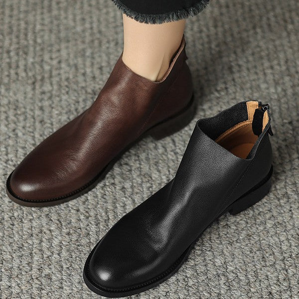Black leather ankle boots with low block heel and back zip, pair on carpet
