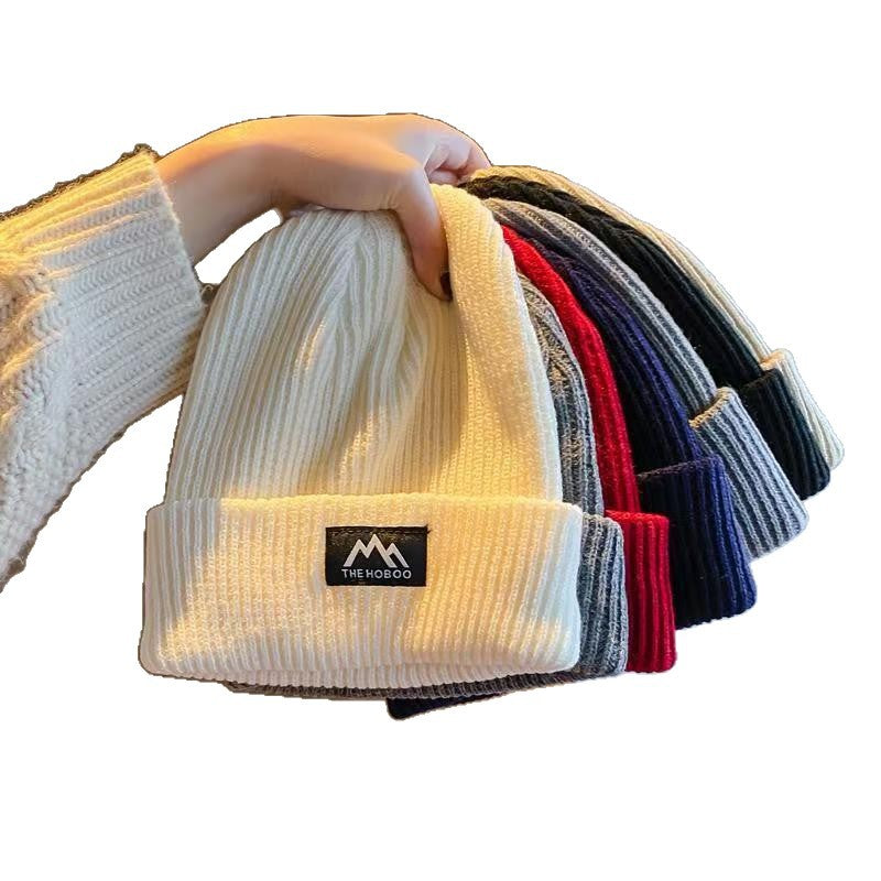 Color assortment of ribbed knit beanies with folded cuffs and woven brand patches.