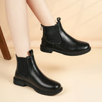 Women’s black Chelsea boots with elastic gore and low block heel, side view