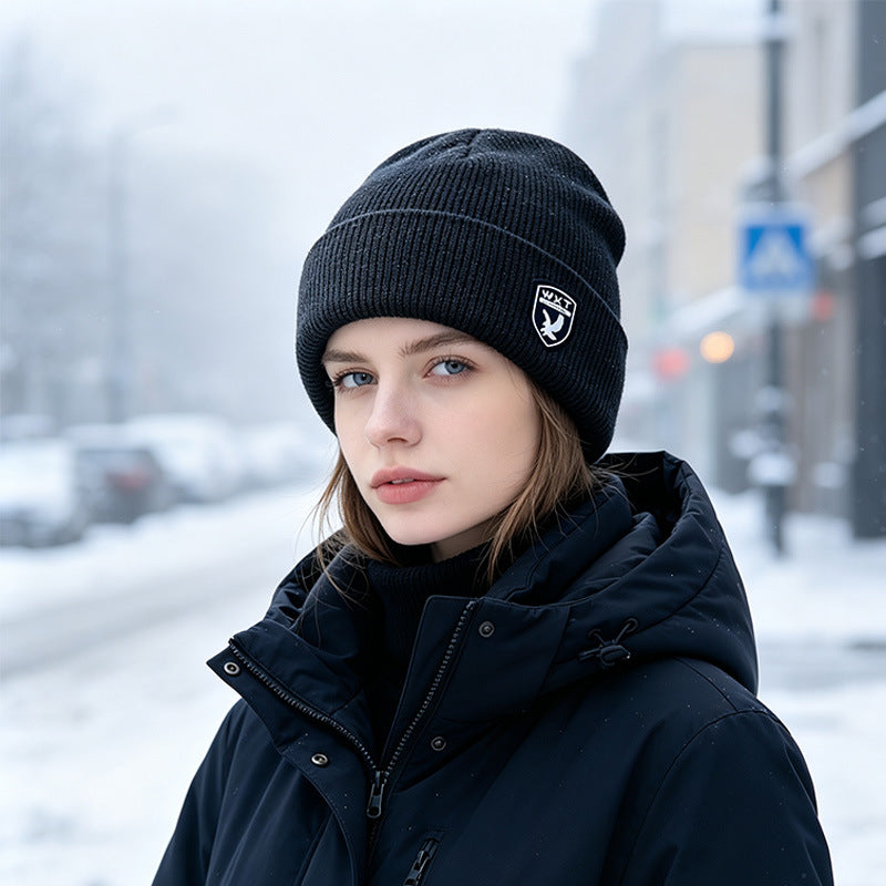 Black ribbed knit beanie with fleece lining and logo patch