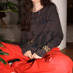 Dark brown long-sleeve graphic tee with star print and relaxed crew neckline