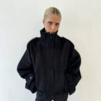 Black cropped wool jacket, funnel neck, button front, epaulettes, cuff tabs.