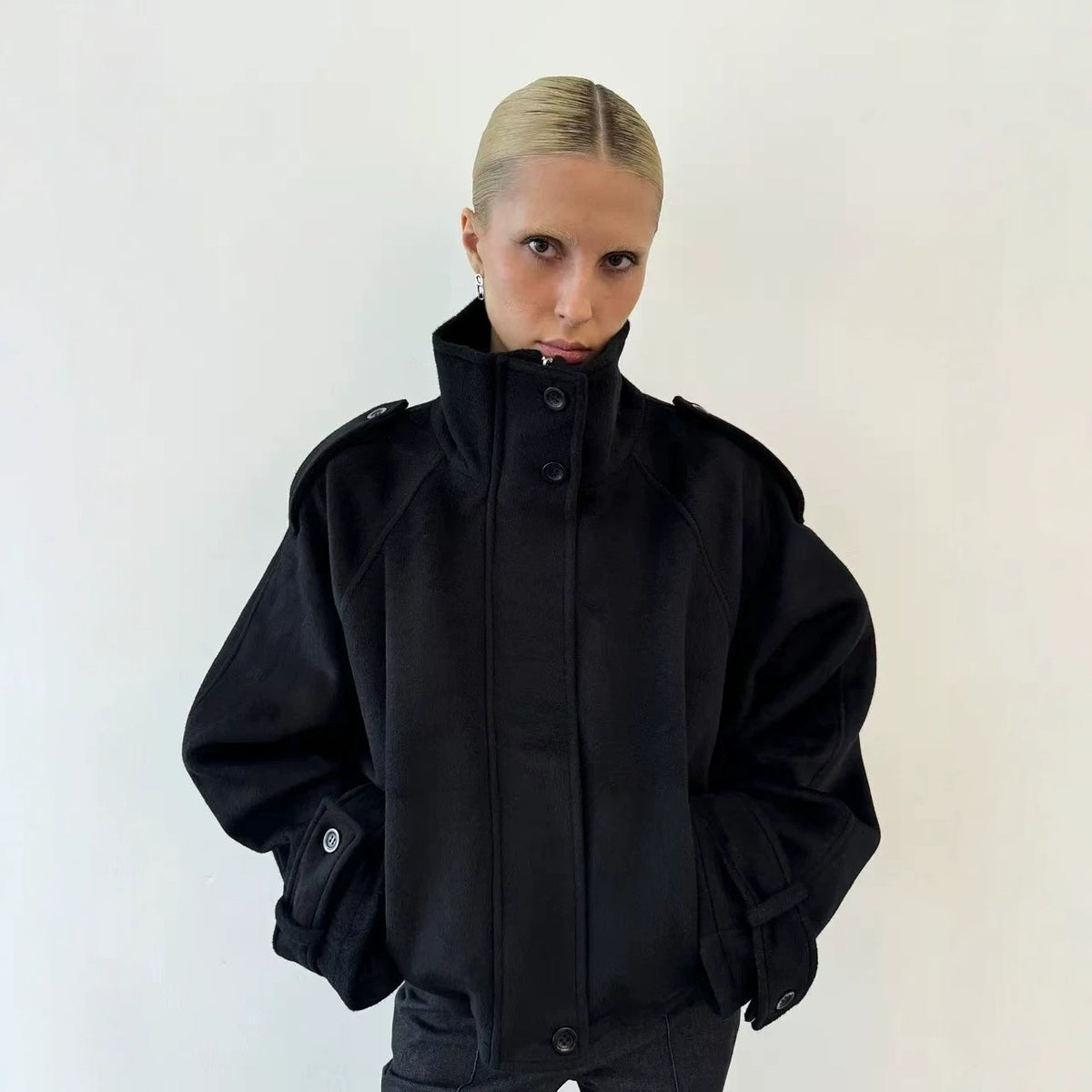 Black cropped wool jacket, funnel neck, button front, epaulettes, cuff tabs.