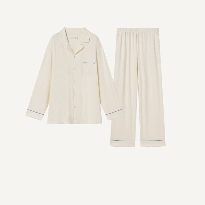 Cream pajama set with long-sleeve button-up top, chest pocket, and contrast-piped pants