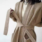 Beige knit cardigan with shawl collar, belt tie, and patch pocket detail