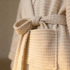 Cream cotton waffle knit robe belt tie knot, shawl-collar detail in close-up