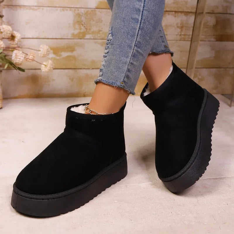 Black faux suede ankle boots with chunky platform soles worn with jeans