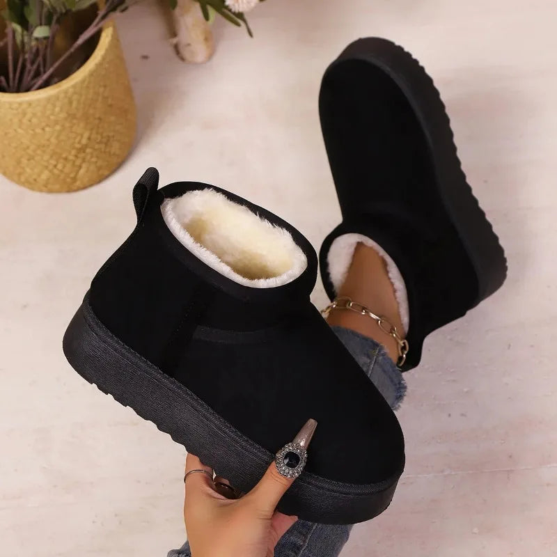 Black faux suede boots with cream fur lining and thick soles, one sole turned upward
