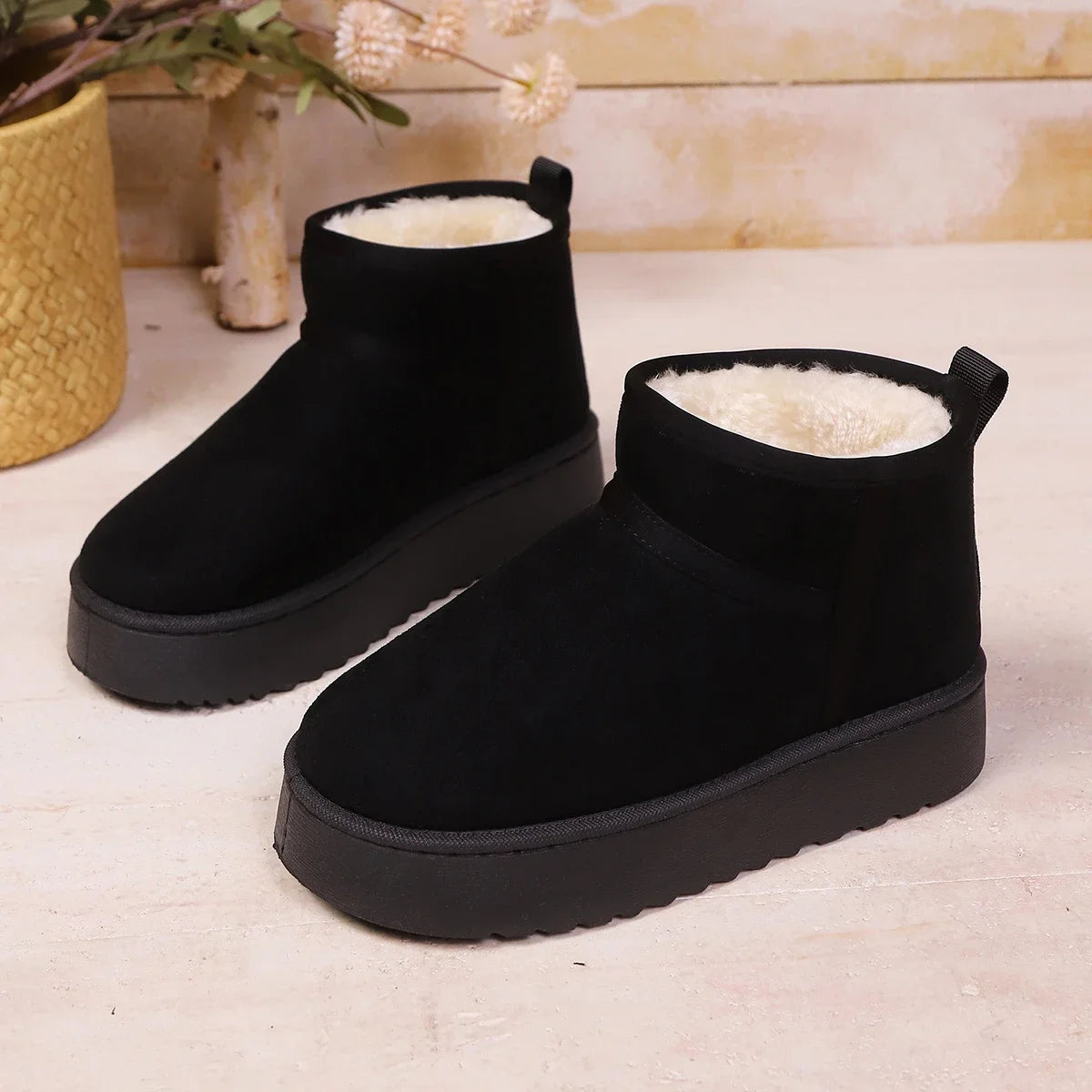 Black faux suede pull-on ankle boots with cream fur lining and thick tread soles