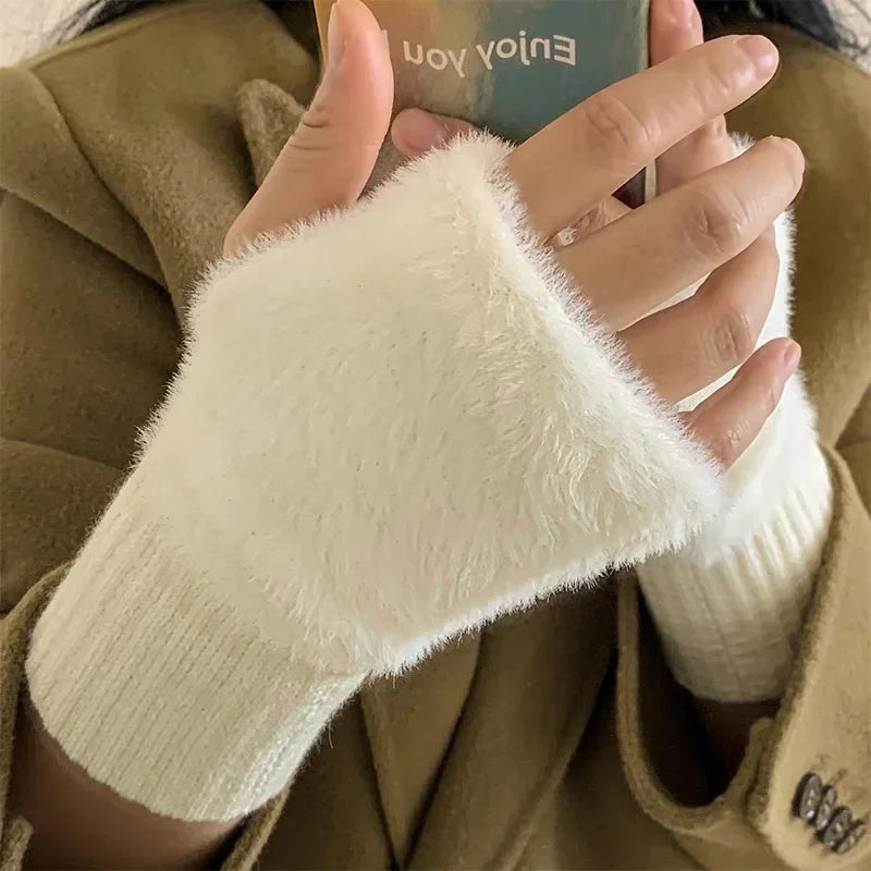 White fuzzy half-finger gloves with ribbed cuffs, shown on hands