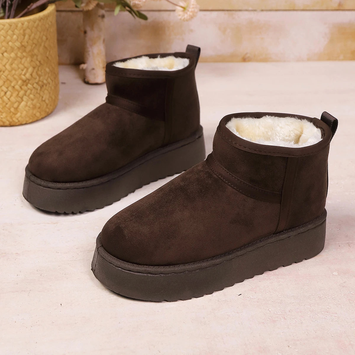 Dark brown faux suede ankle boots with plush cream lining and thick tread soles