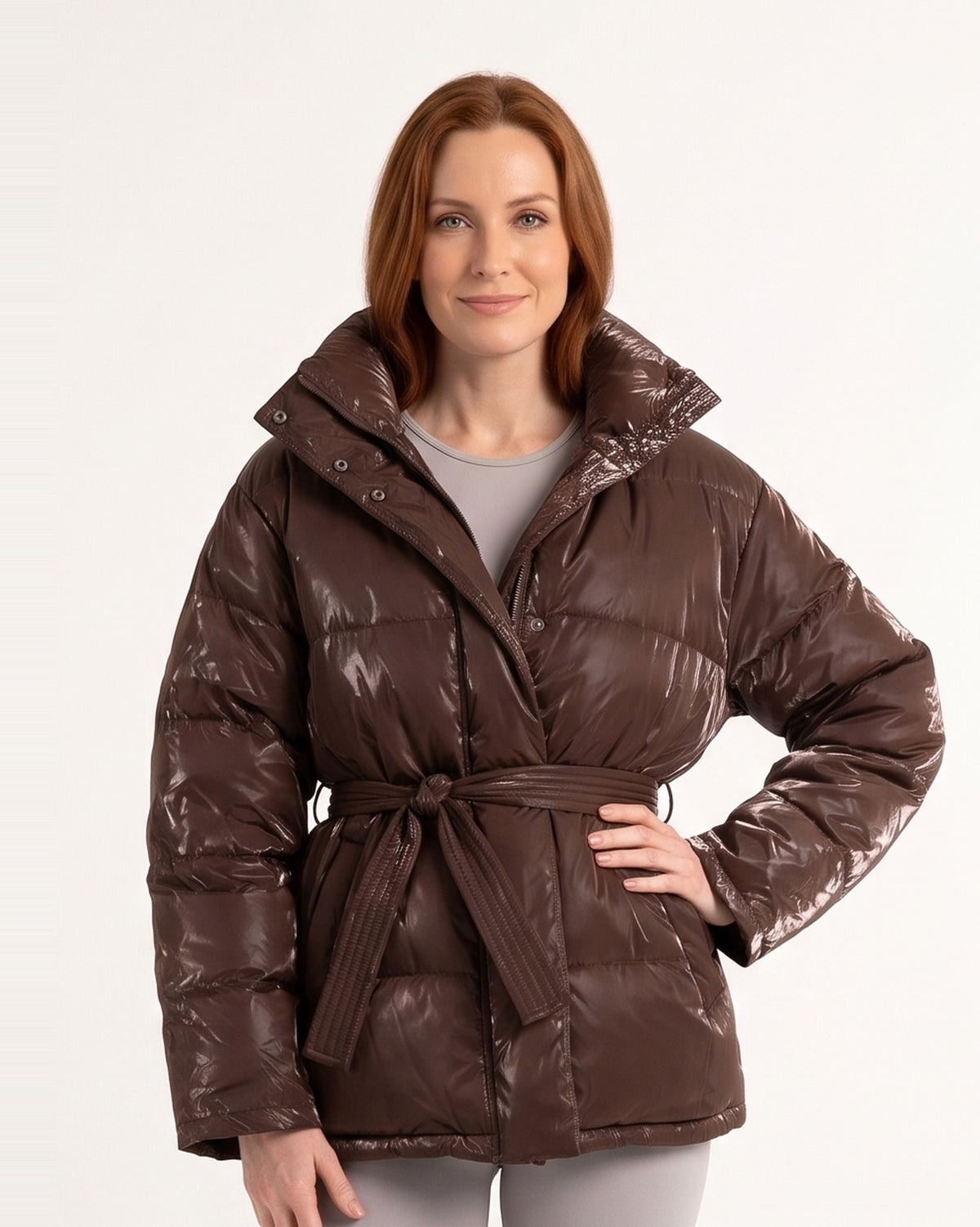 Women’s belted puffer jacket in glossy dark brown with oversized hood and tie waist