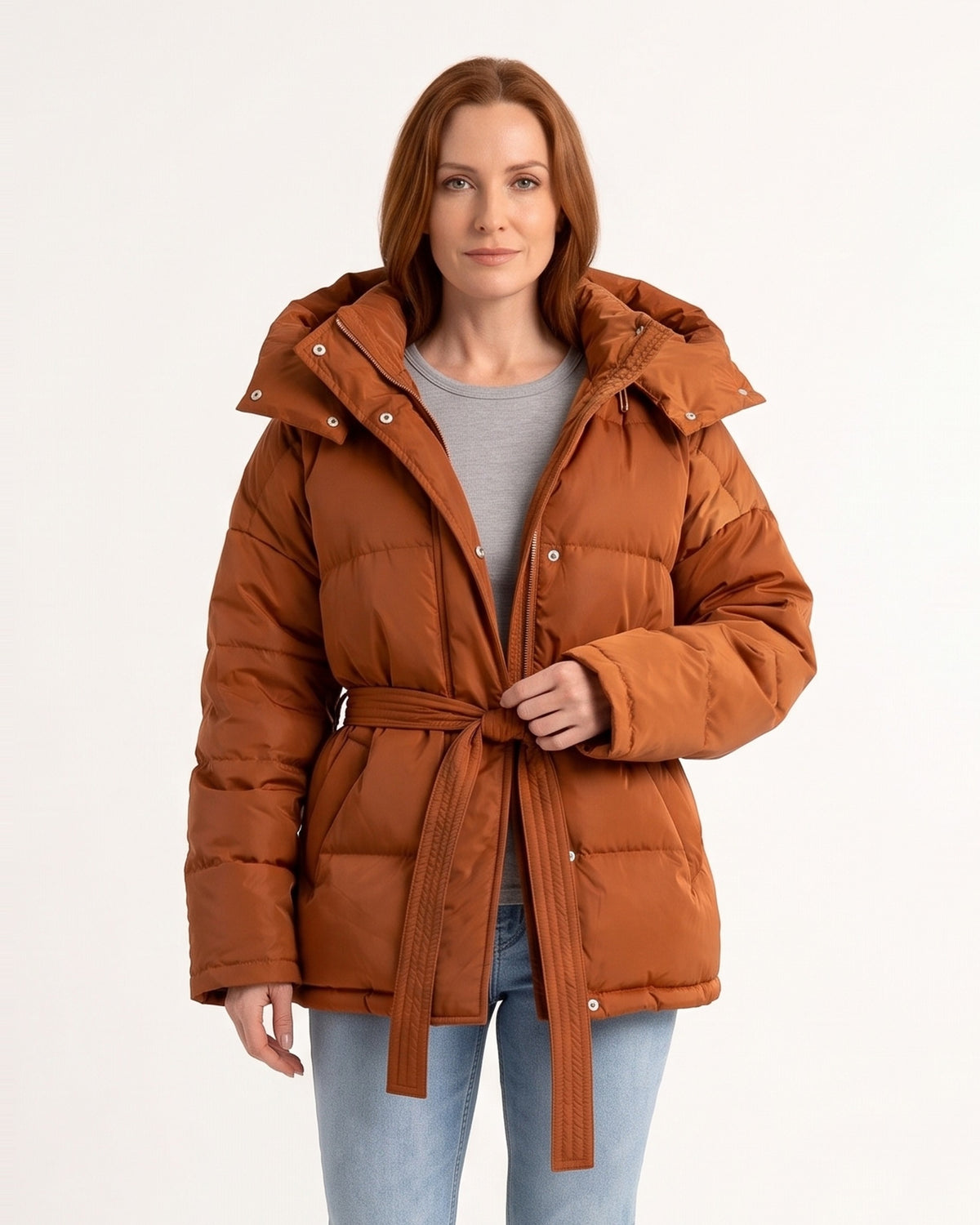 Women’s belted puffer jacket in glossy orange-brown with oversized hood and tie waist
