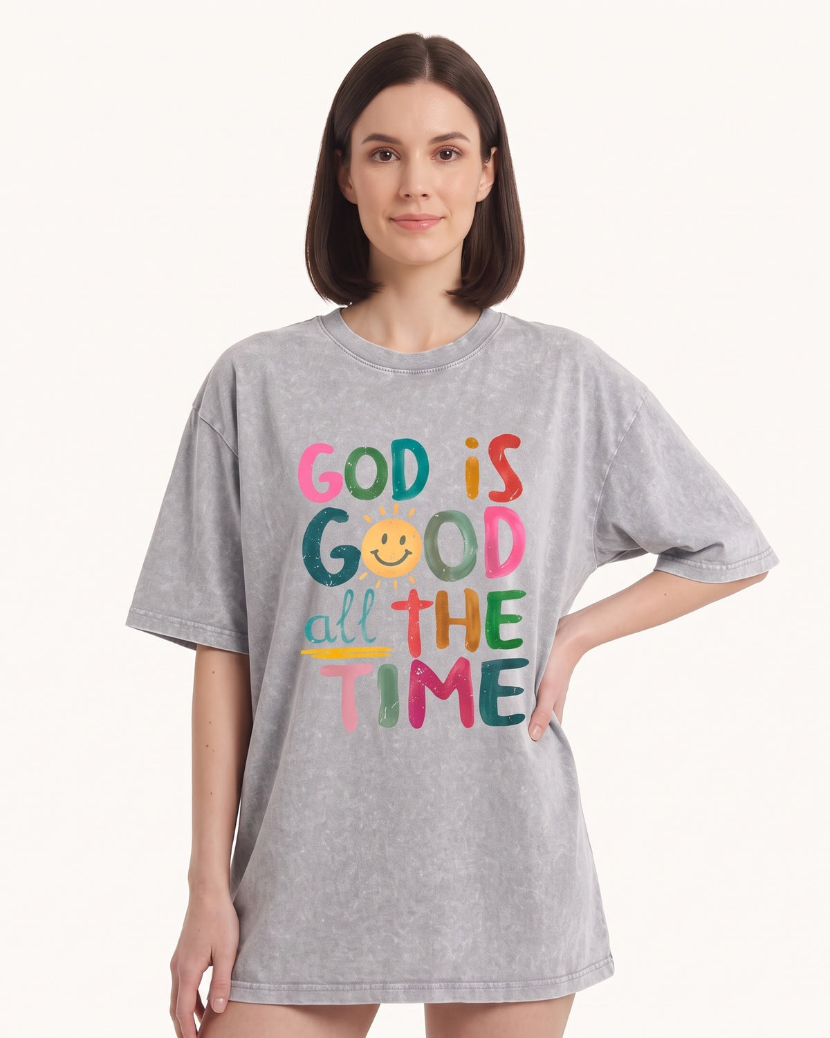 Women's oversized graphic T-shirt in light gray with colorful 'God is Good' print