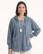 Light blue corduroy oversized pullover hoodie with drawstring hood and patch pockets.