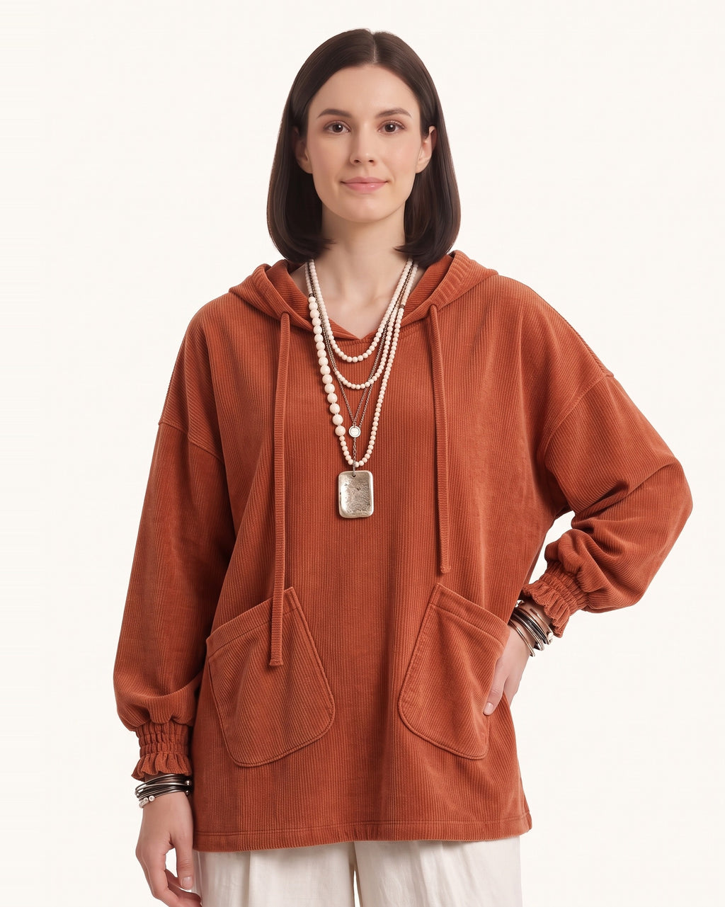 Burnt orange corduroy oversized pullover hoodie with drawstring hood and patch pockets.