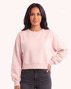 Light pink cropped sweatshirt with a crew neck, oversized fit, and ribbed hem