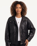 Black faux leather jacket with stand collar, front zip, and flap chest pockets