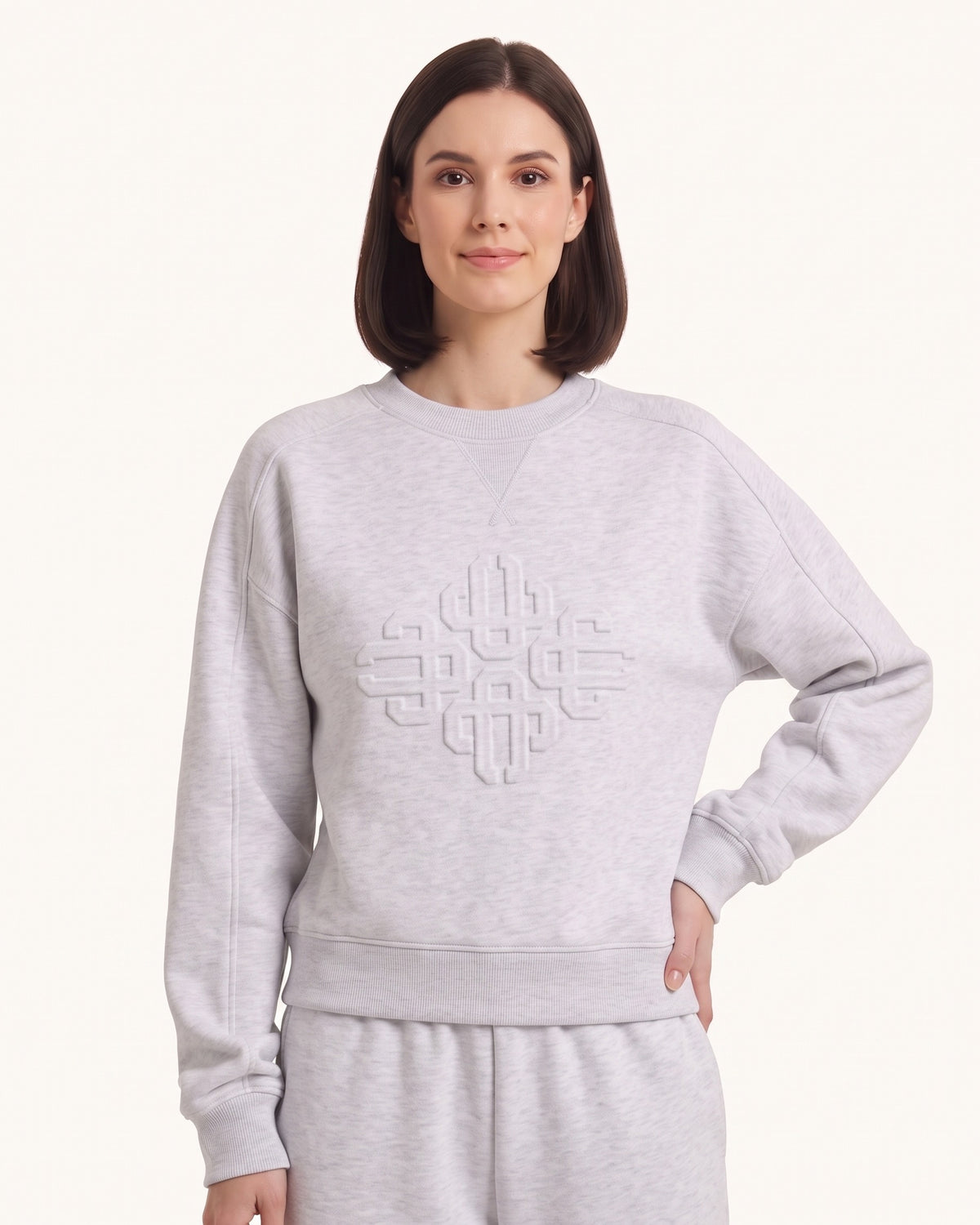 Women’s gray crewneck sweatshirt with embossed geometric logo and relaxed raglan fit