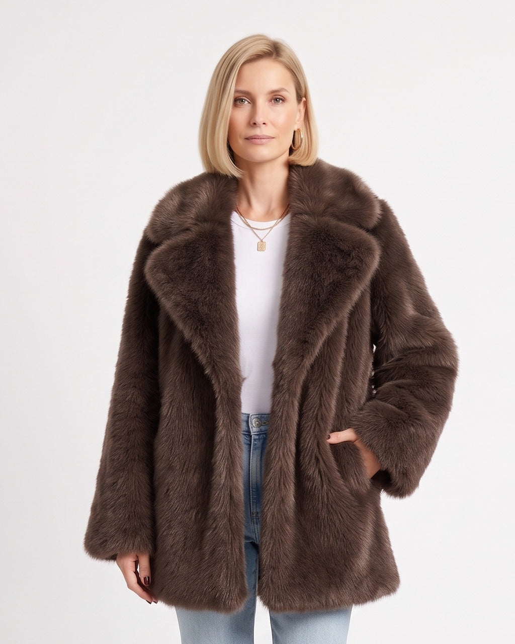 Brown fluffy faux fur coat with wide lapels and a hand tucked into a side pocket