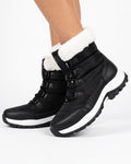 Women’s black faux fur lined lace-up snow boots on model, side view with lug sole.