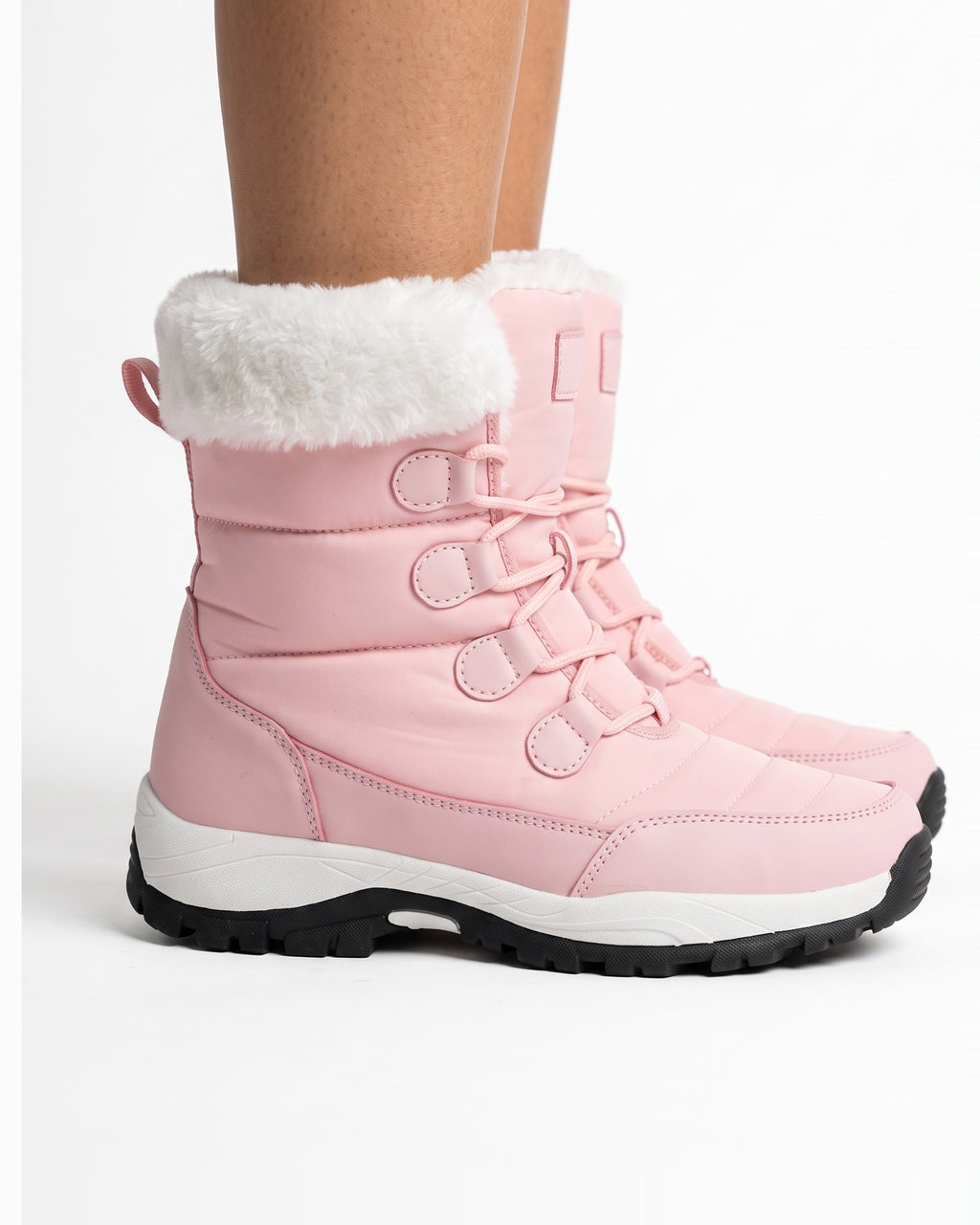 Women’s pink faux fur lined lace-up snow boots on model, side view with lug sole.