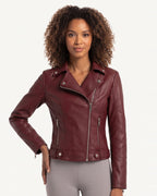 Burgundy moto jacket on model, asymmetrical zip front, snap collar, side zip accents.
